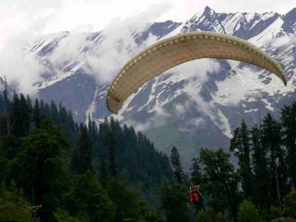 a person in a parachute over a mountain