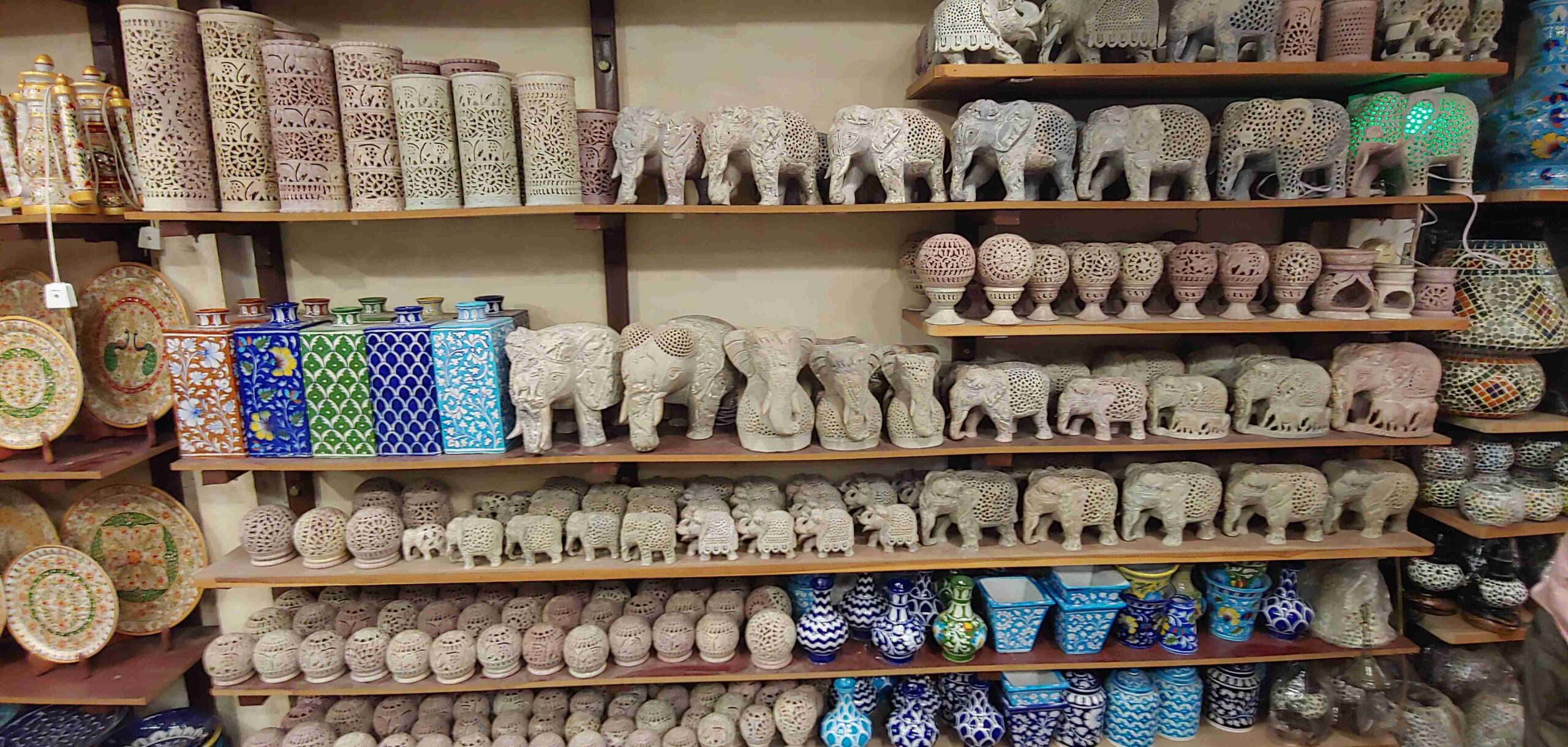 a shelf full of ceramic elephants