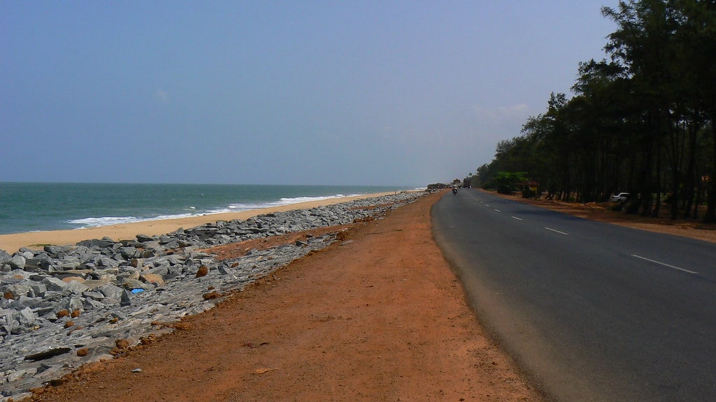 a road with rocks on the side and a beach