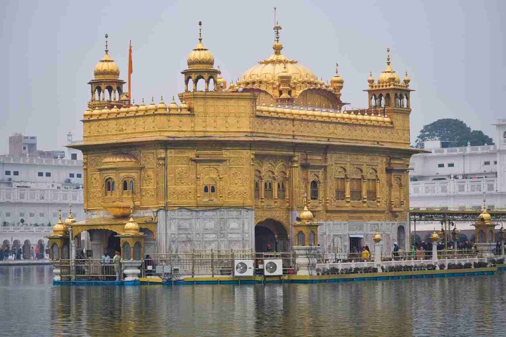 Harmandir Sahib with gold domes and a body of water